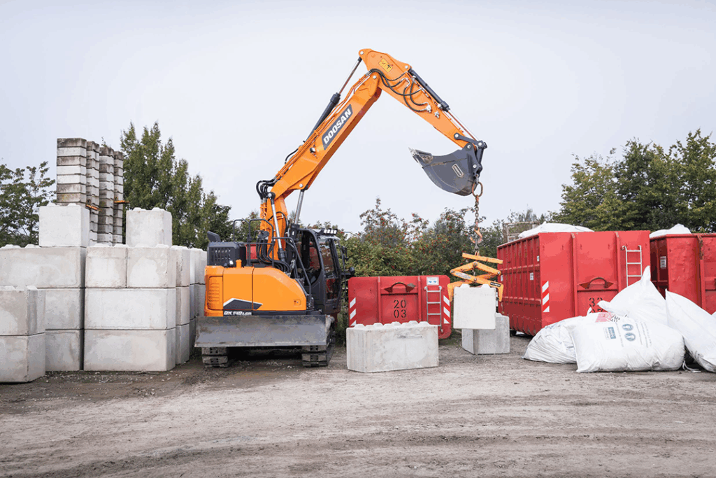 Doosan DX140LCR-7 Reduced Tail Swing Excavator picking up concrete block